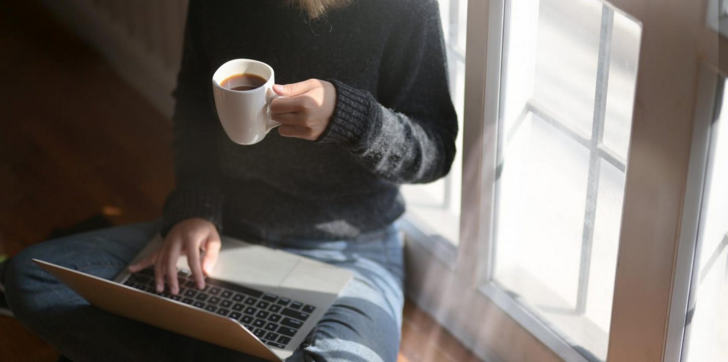 girl on laptop drinking coffee